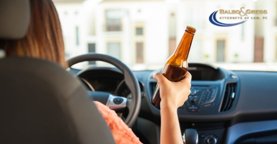driver holding a beer bottle